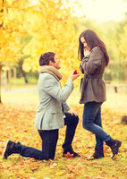 Man proposing to woman autumn park holidays love couple relationship dating concept kneeled me