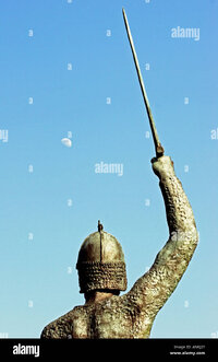 back-view-of-statue-of-warrior-holding-upraised-sword-at-moonset-in-ANKJ2Y.jpg